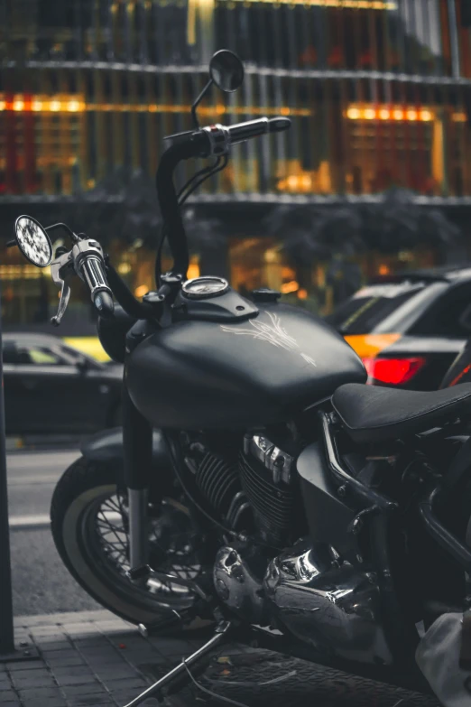 a parked motorcycle near a street in front of a building