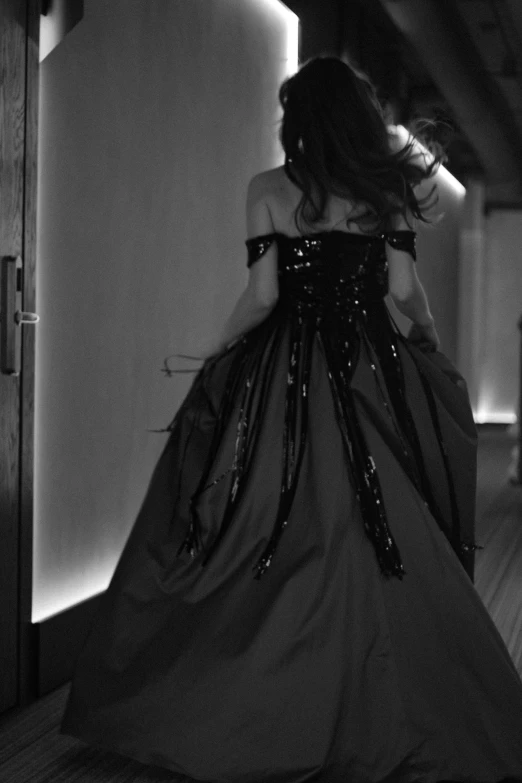 the back of a woman in a long black dress