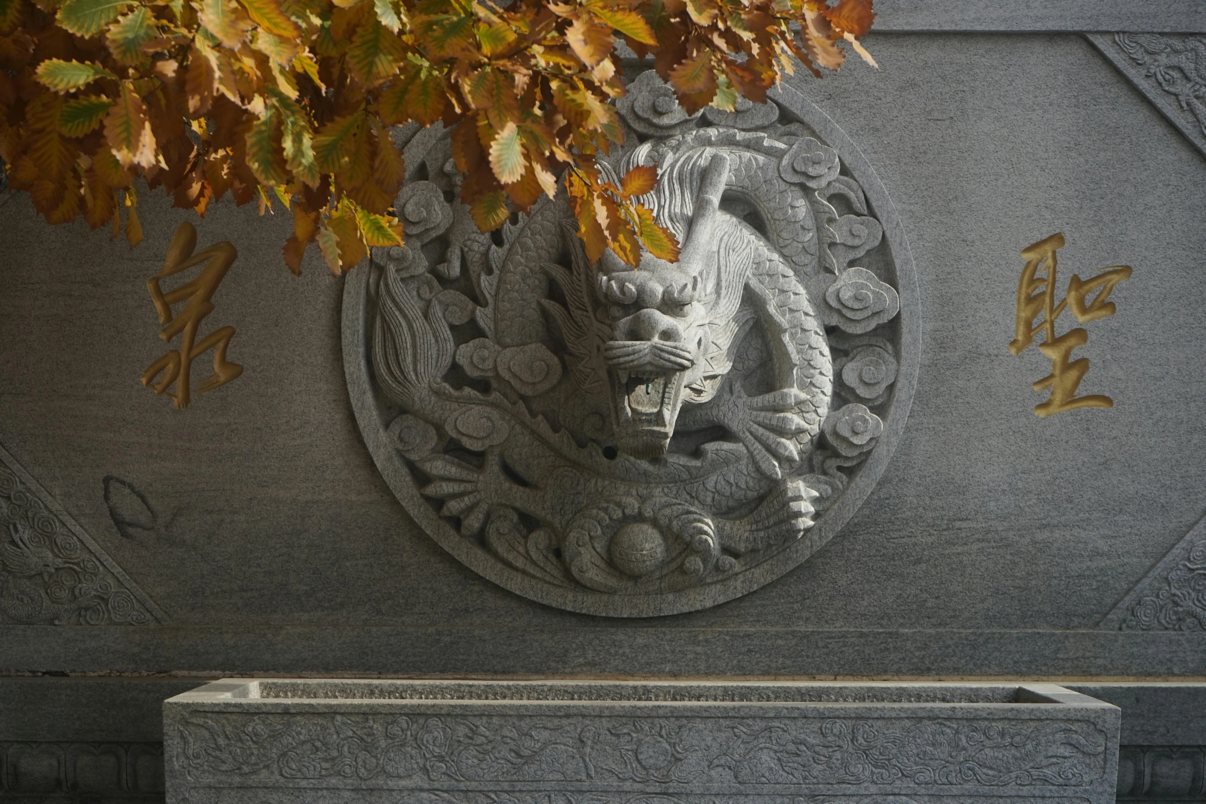 a large stone sculpture has writing and symbols