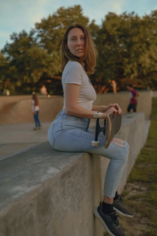 a girl is sitting down on the edge of a wall