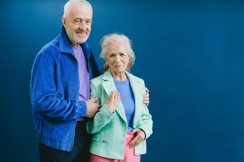 a man and a woman standing in front of blue backdrop