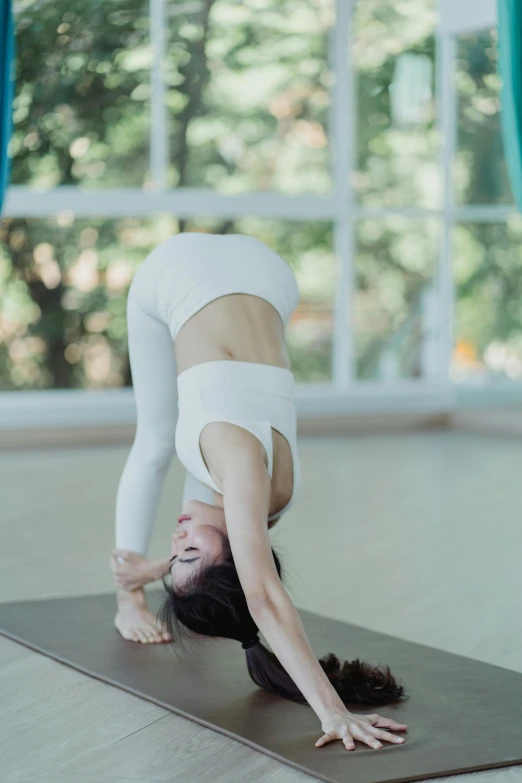 woman practicing yoga in a room with bright windows