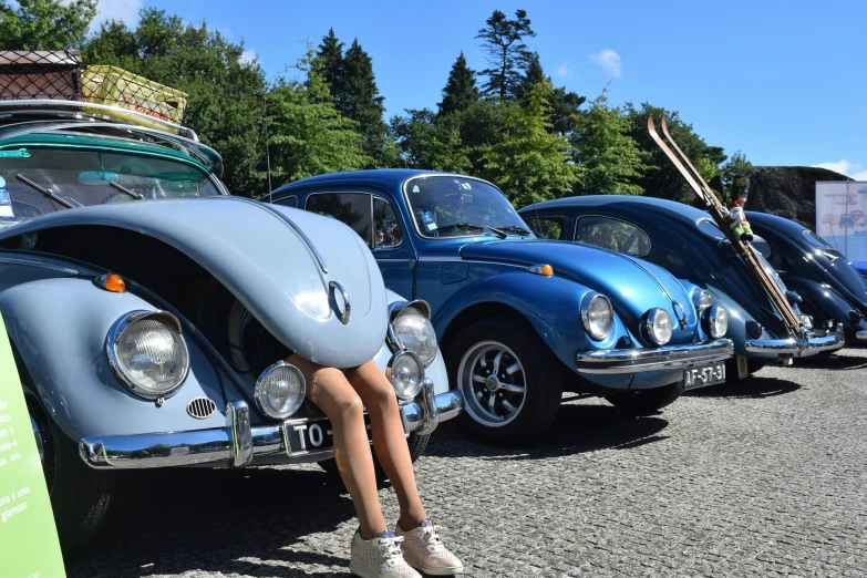 woman in a bikini sitting in front of three beetlegies