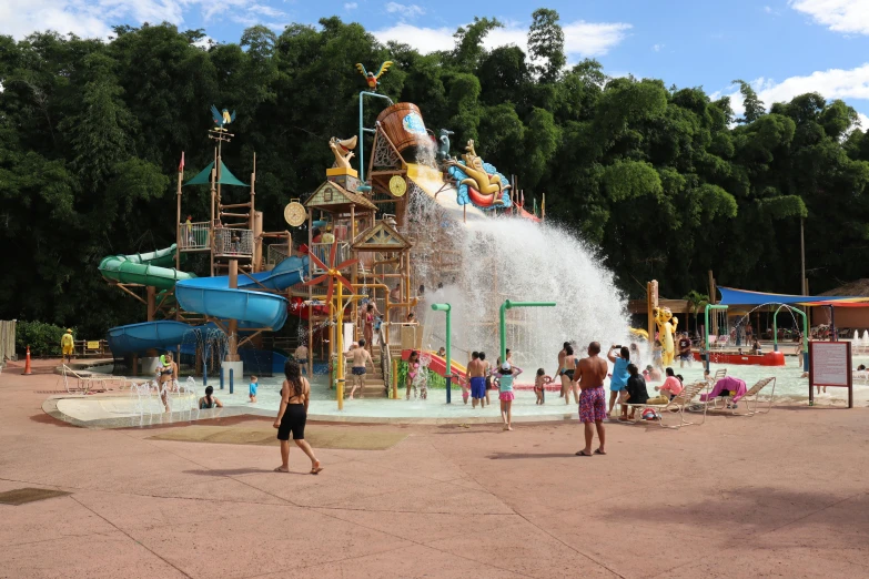 several people are enjoying the park with water splash