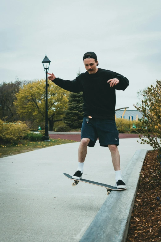 a man wearing a hat and glasses is on his skateboard