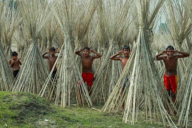 a group of men standing around dried grass