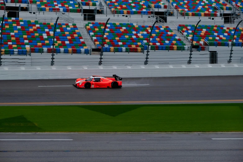 a red car going down the road at a race