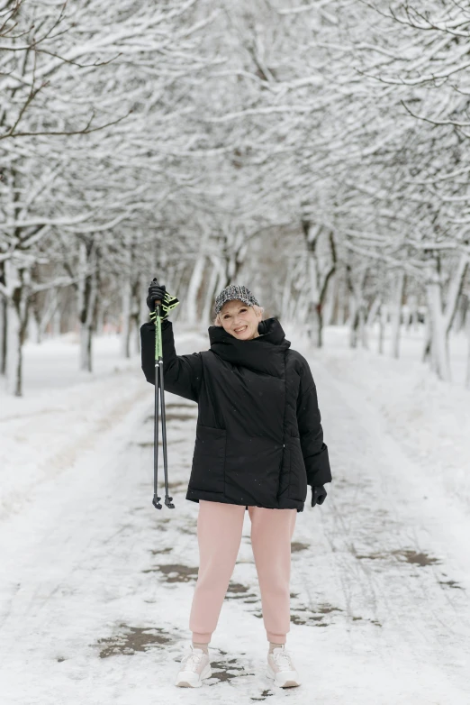 the woman is walking in the snow holding skis