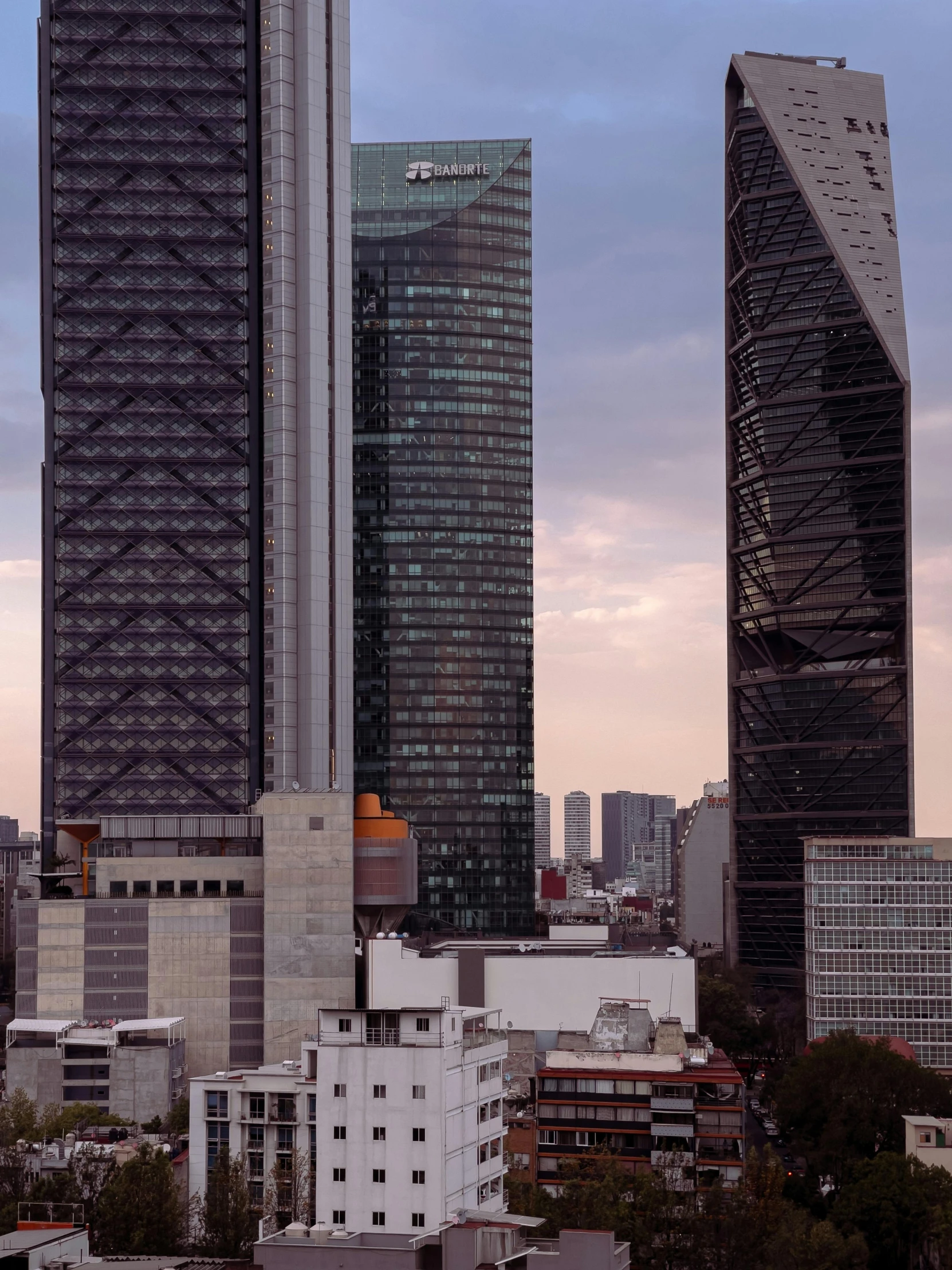 some tall buildings sitting on top of a green field