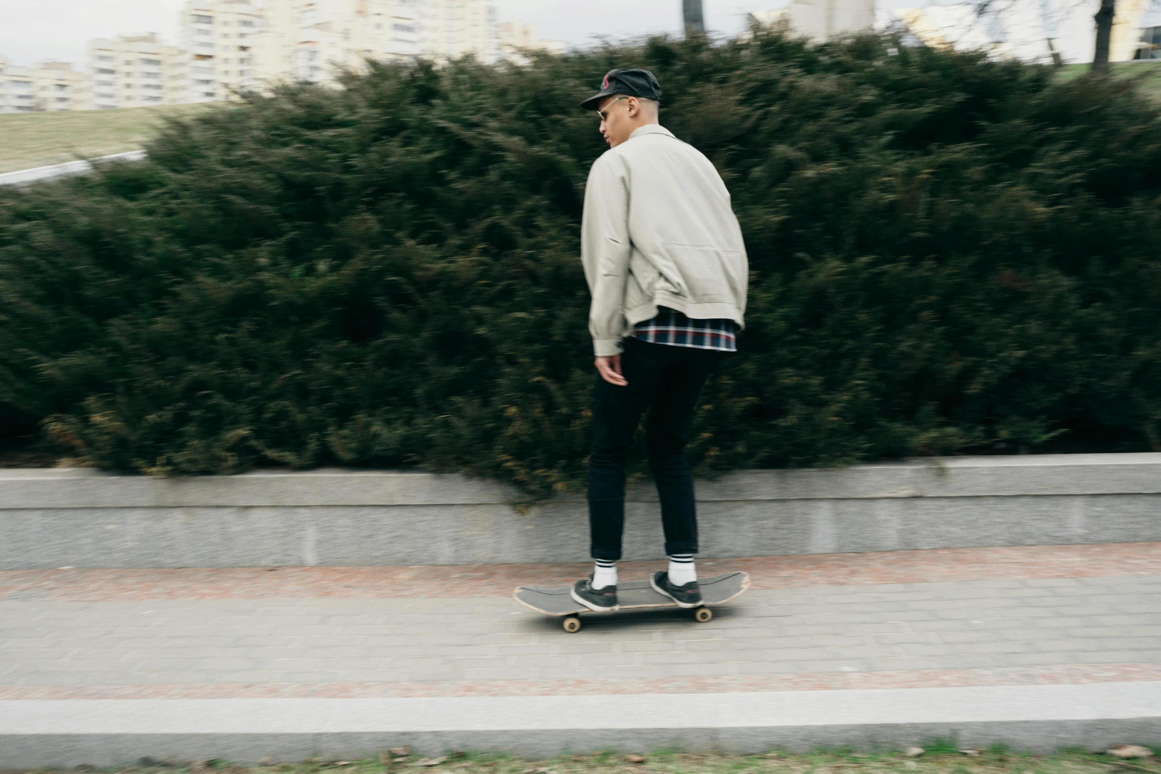 there is a male skateboarder that is going down the street