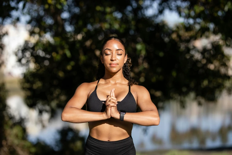 woman in a black sports  and dark gray workout outfit doing a yoga pose