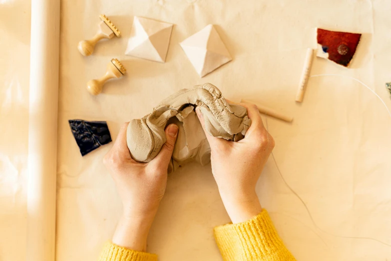 the pair of hand is touching an object on the table