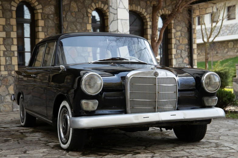 an antique car sits parked in front of a mansion