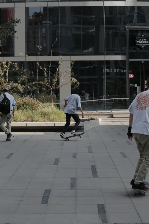 four people walking around on skateboards near buildings