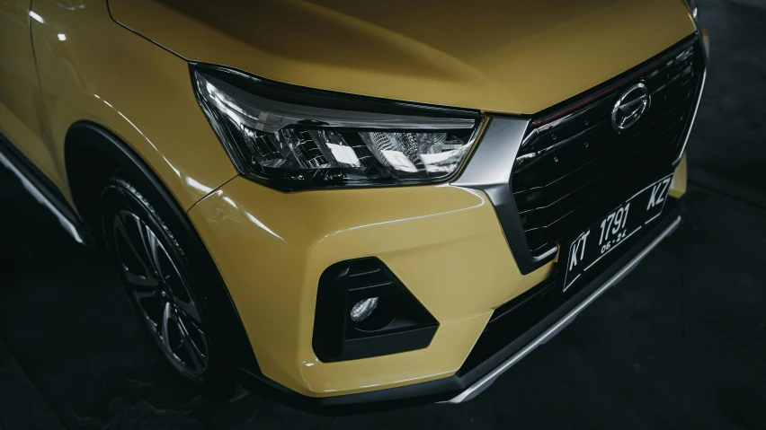 the front grill and headlights on a yellow suv