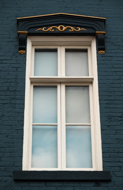 there is a blue brick wall with window and gold trim