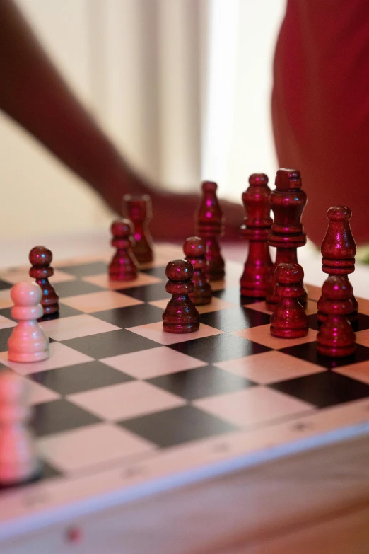 red glass chess pieces on top of a checkerboard board