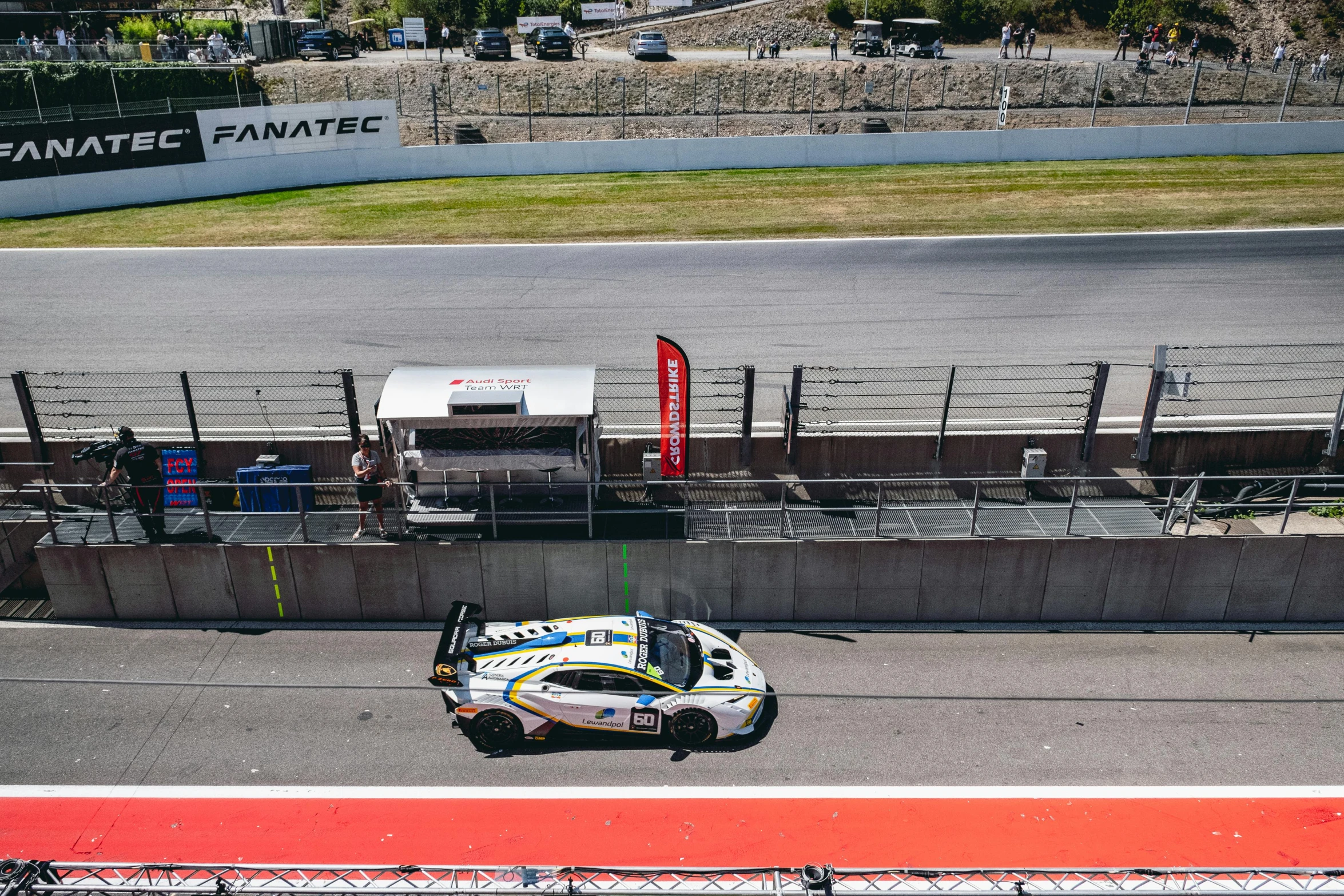 a race car on a race track with spectators looking on