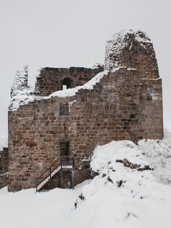 a very tall building covered in snow next to a forest