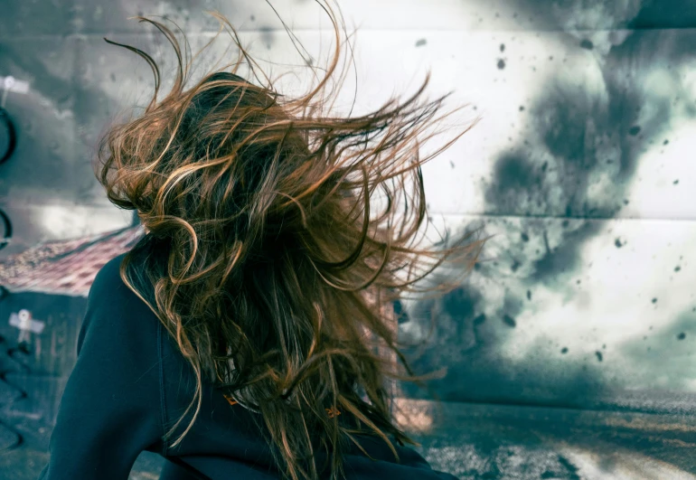 a woman with long hair that is standing on a skateboard