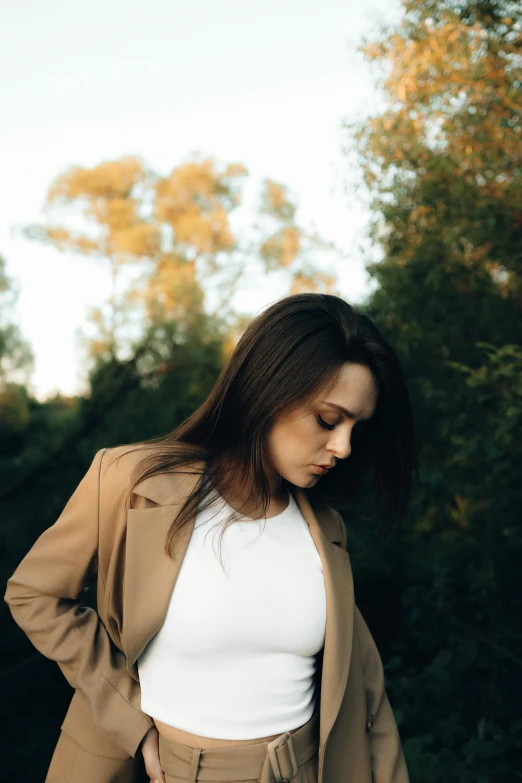 a woman standing outside wearing a tan blazer