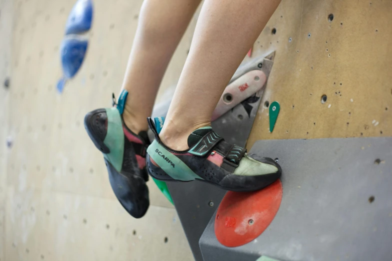 a close up of two people on a climbing wall