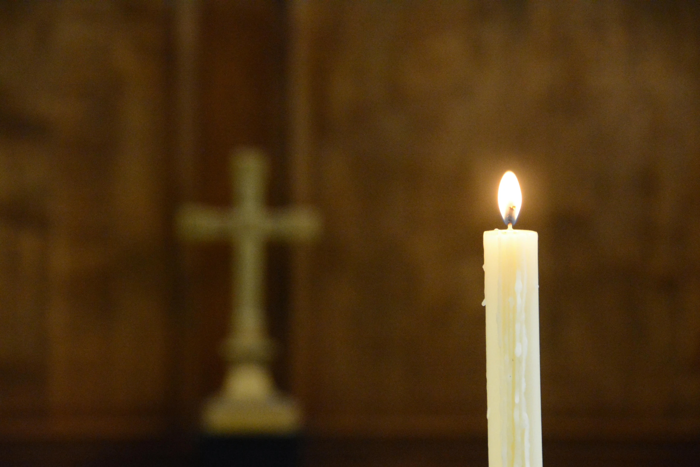 a candle sits in front of a cross