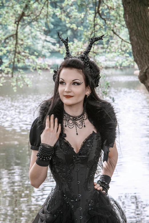 a woman dressed in black, with horns and feathers