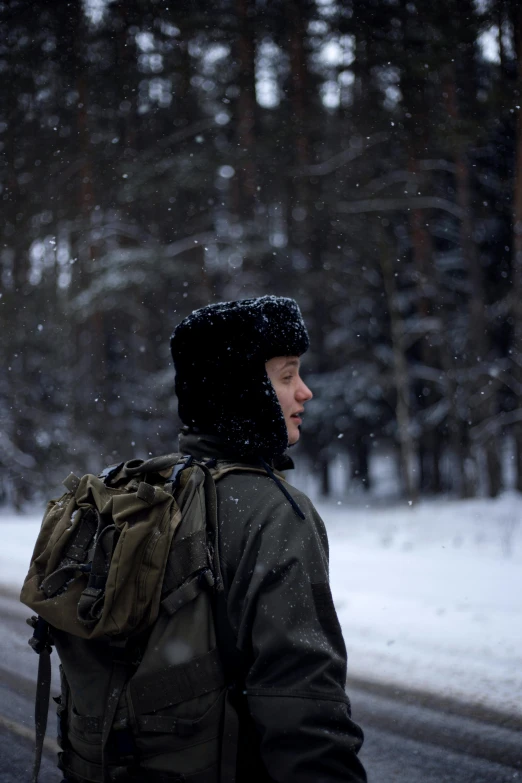 a man with a backpack is walking through the snow