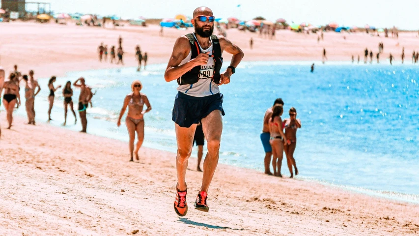 a man in the running attire, running on a beach