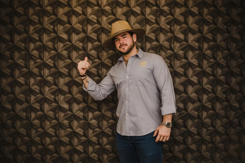 a man with a hat holding up his peace sign