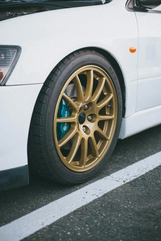 a white car parked near a curb with a yellow tire