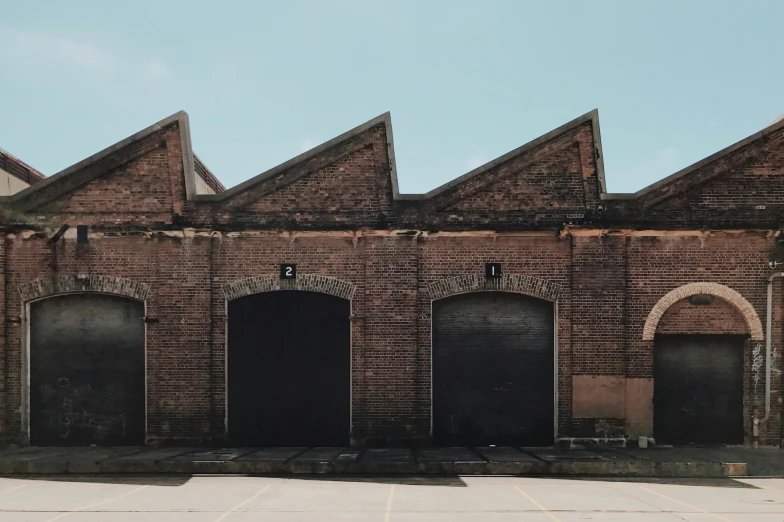 a set of three garage doors on a brick building