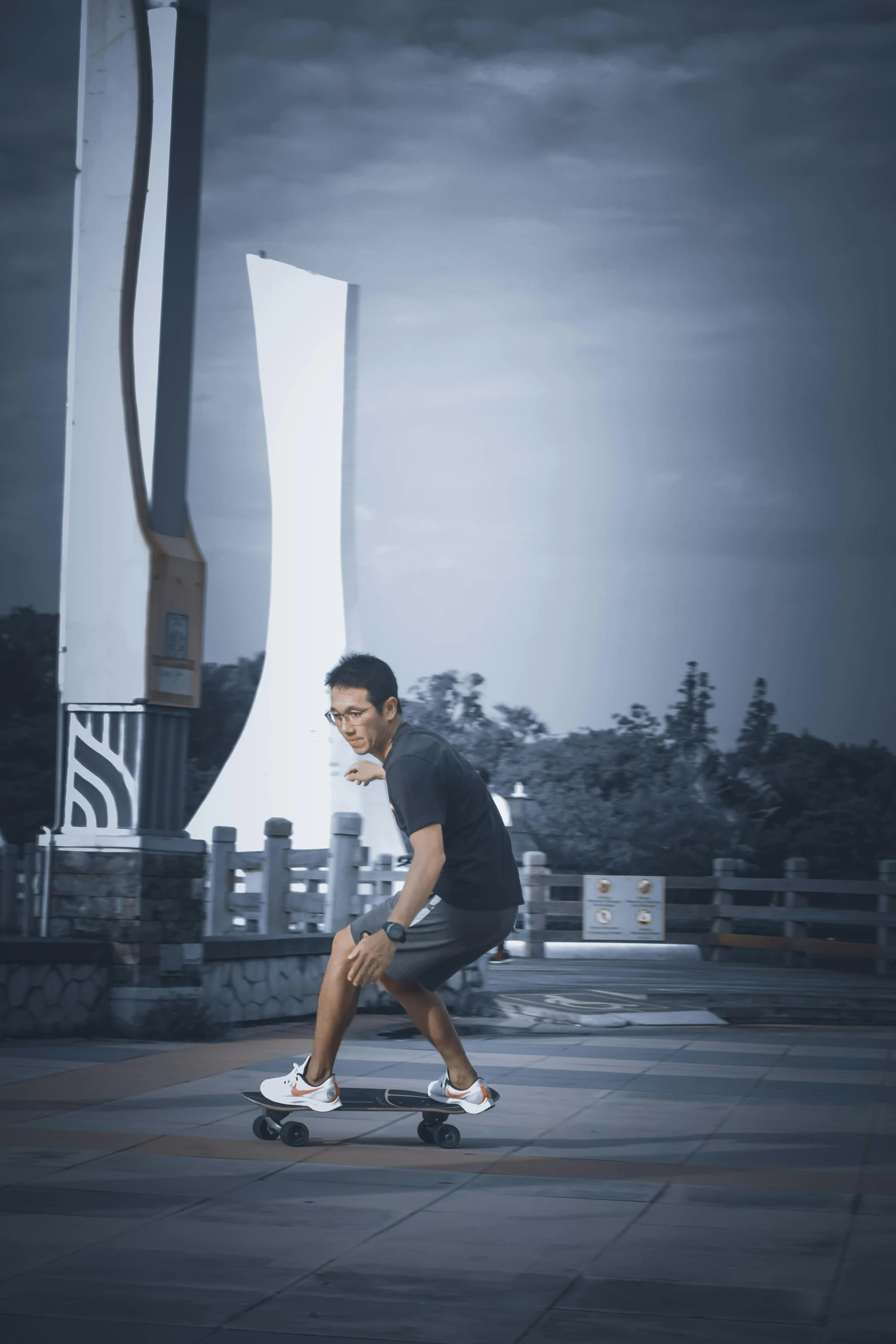 a man skateboarding on the concrete under an overcast sky