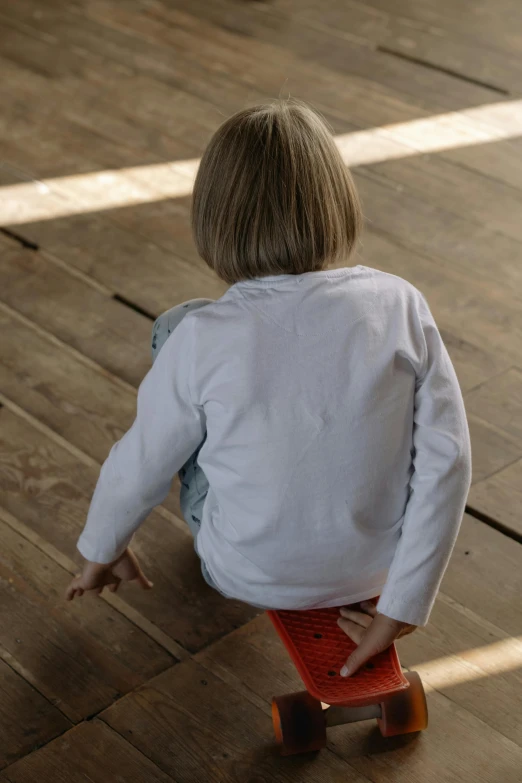 a boy is riding on a skateboard in the room