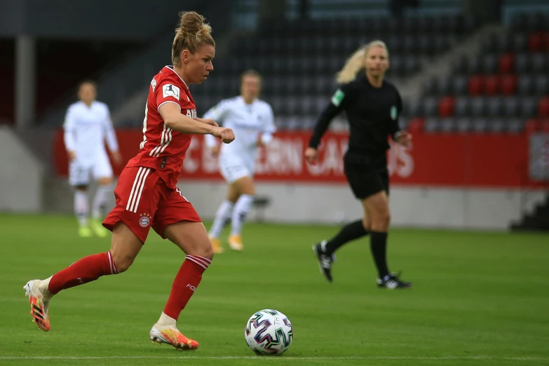 two soccer players running towards a ball in a field