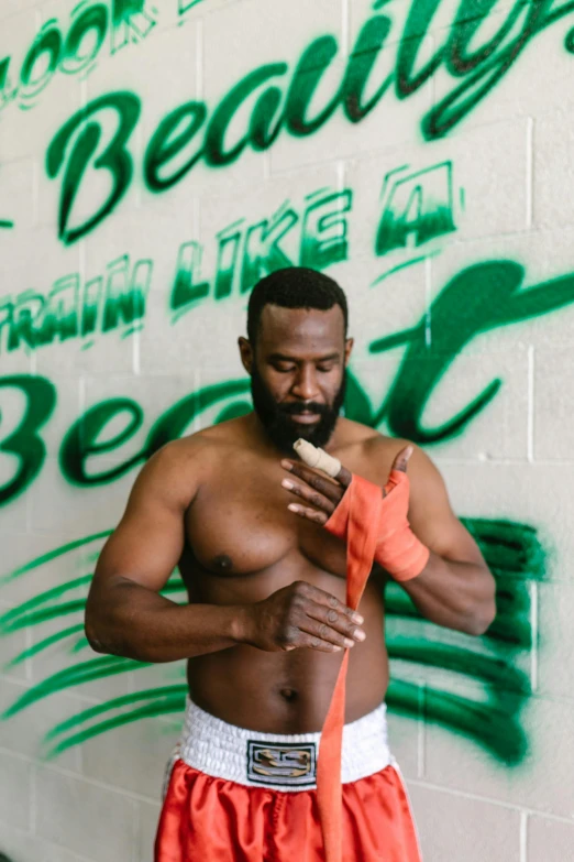 a man standing in front of a wall with his shirt open and his pants closed