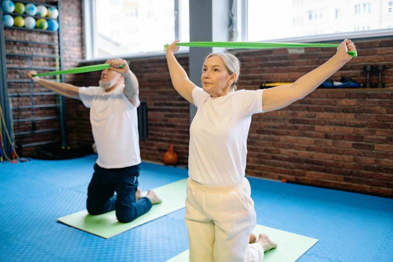 two women engaged in a yoga exercise with hoop swords