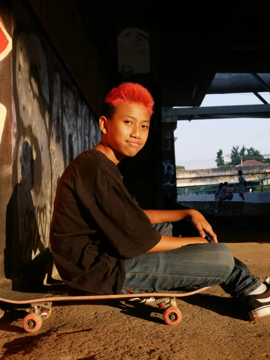 a  sitting on top of a skateboard