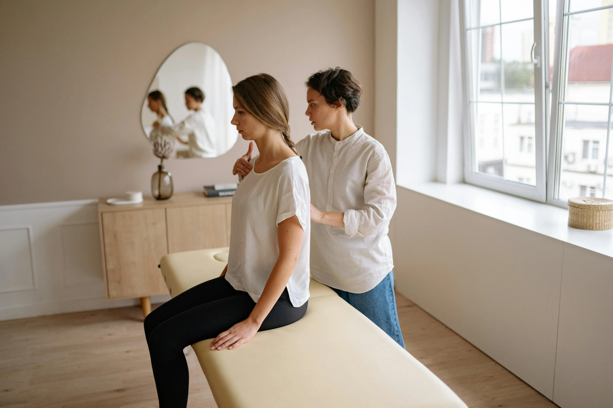 two women are doing their hair while they sit in front of the mirror