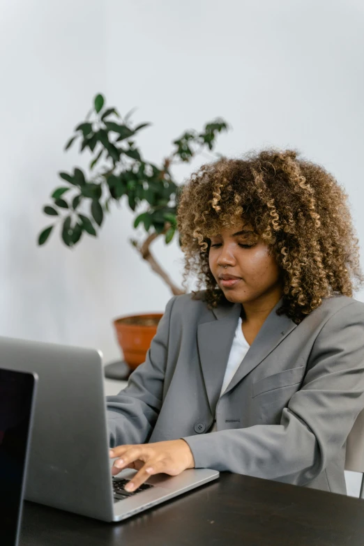 a woman is sitting in front of a laptop