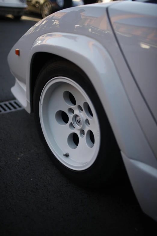 the wheel of a sports car is on the street