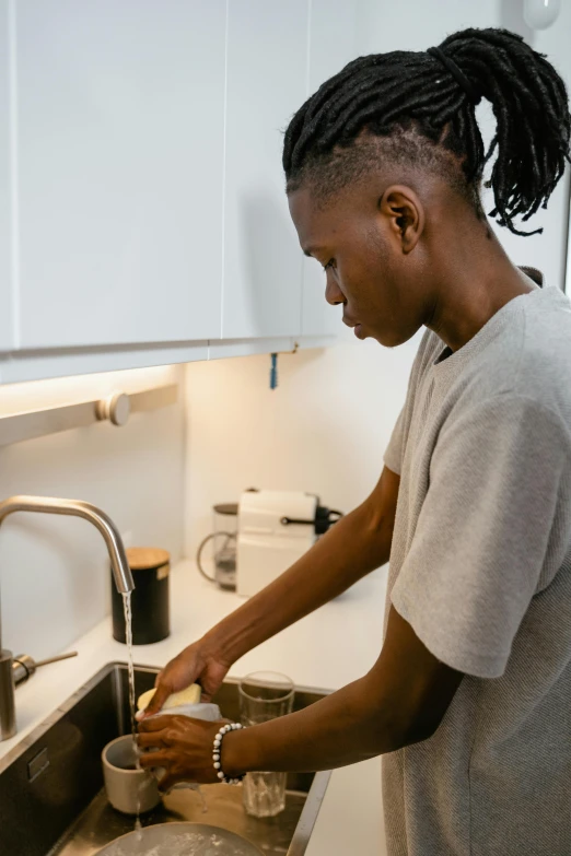 a woman prepares a bowl of food in a sink