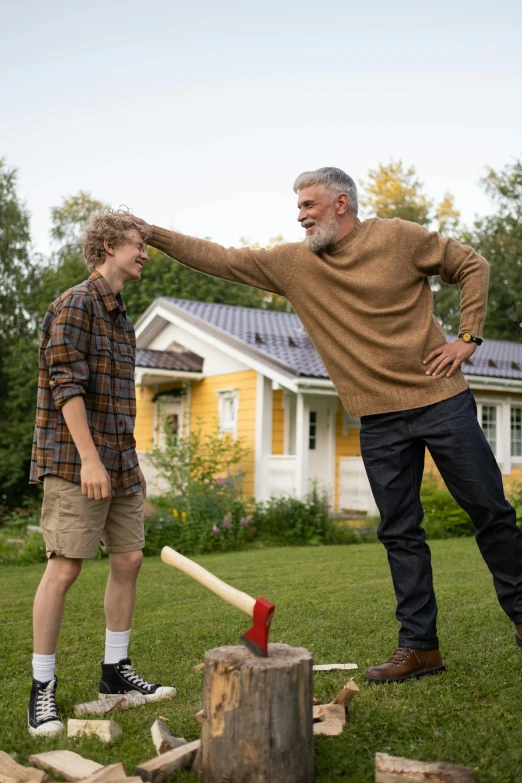 an old man has his arm in a hammer while another mans arm watches