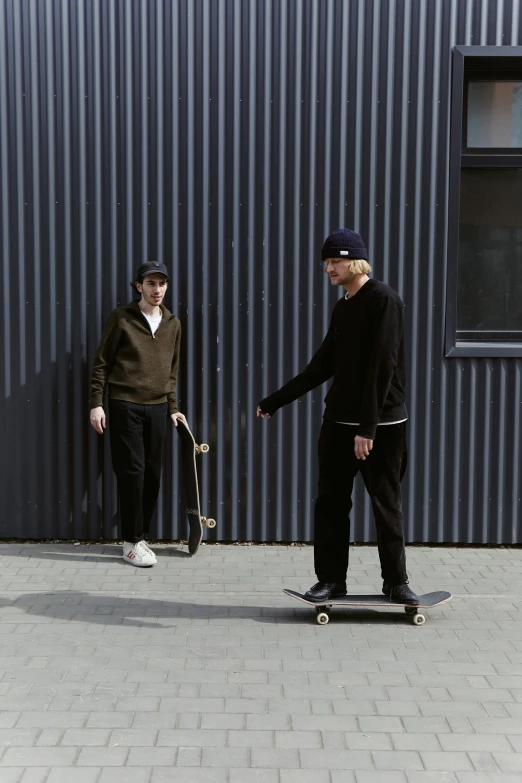 one guy on a skateboard and another person holding a skateboard