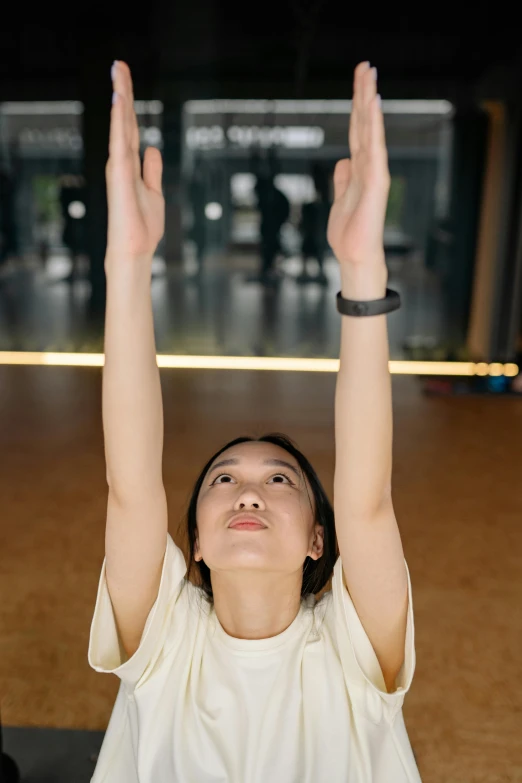 a woman in white holds her hands up