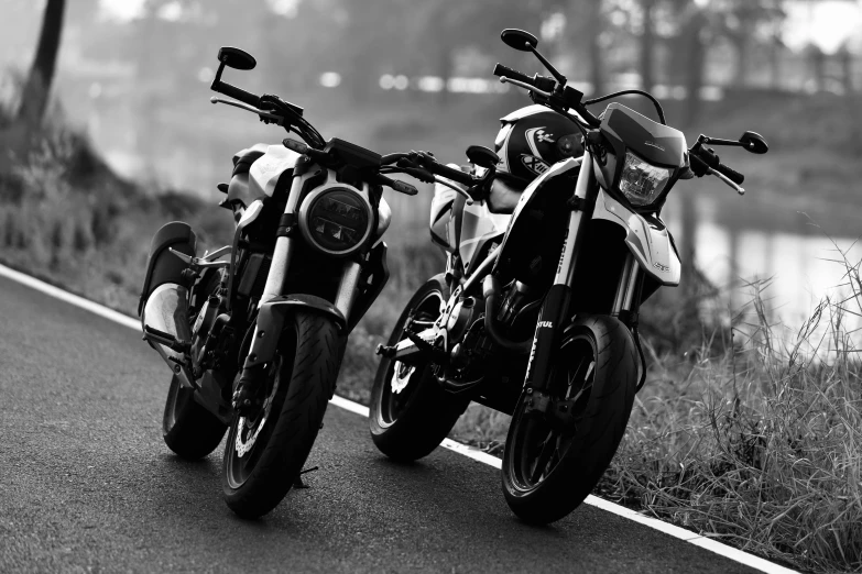 two motorcycles parked side by side on a road