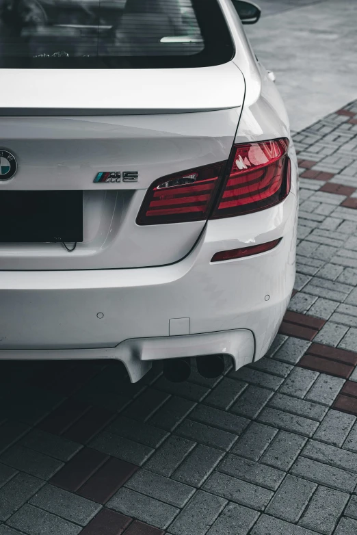 a white bmw sedan parked in a parking lot