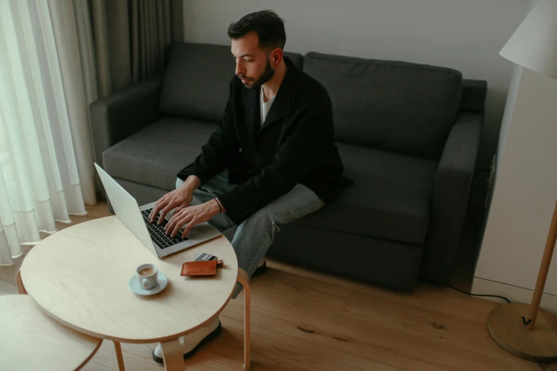 a man sitting on the couch with his laptop