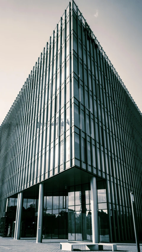 a glass office building is pictured in black and white